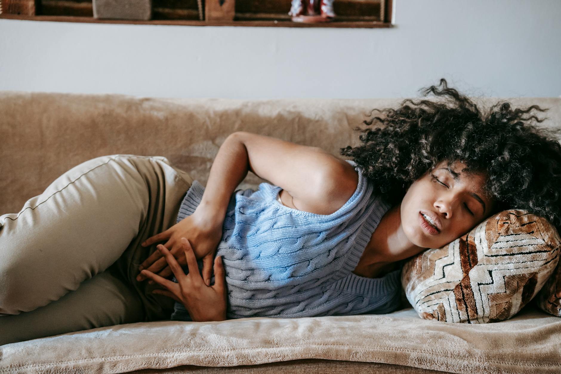 A person sleeping comfortably on their side in bed with a body pillow, demonstrating proper spinal alignment and open chest positioning for healthy breathing during sleep